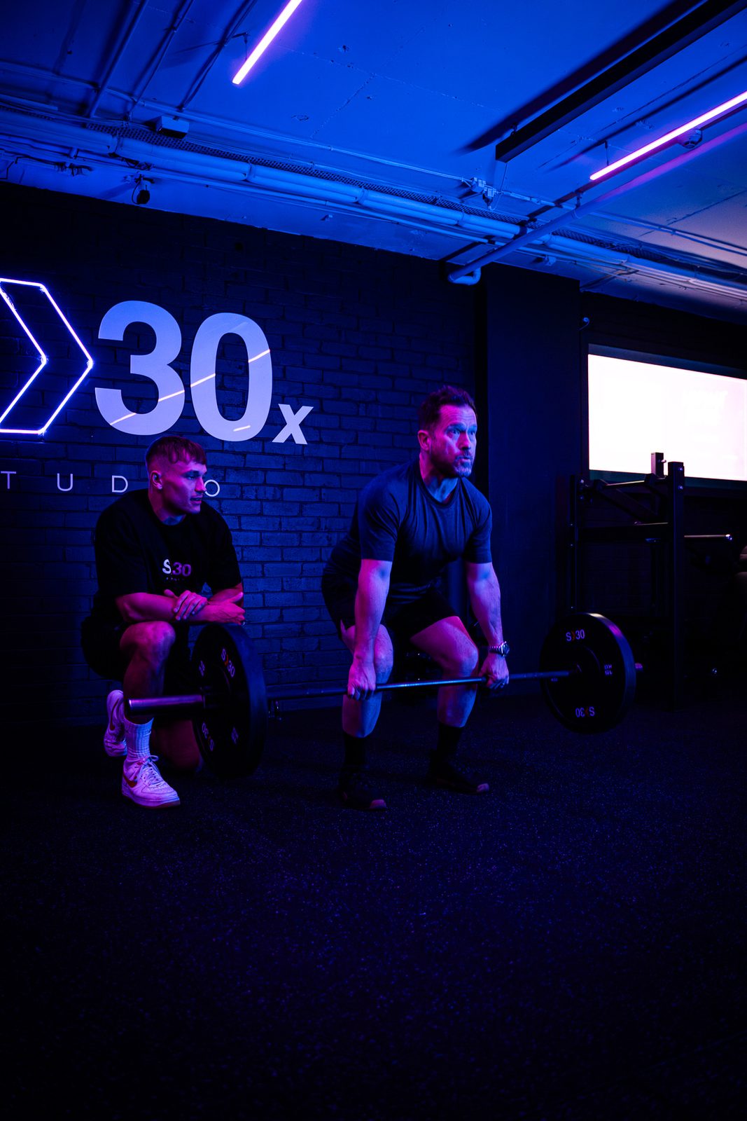 A coach watching a member&rsquo;s deadlift technique during semi-private training